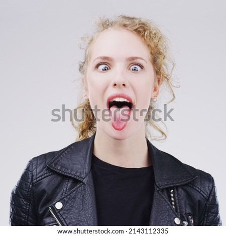Step out of your normal zone. Studio shot of a young woman making a funny face against a gray background.