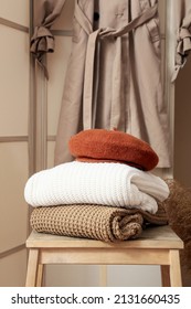 Step stool with stack of warm clothes in hall, closeup