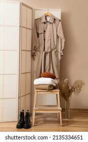 Step stool with stack of warm clothes, boots and vase in hall