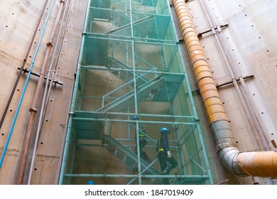 Step zigzag staircase safety with net fall-protection in underground construction site or fire escape, a ladder or stairs outside a building that allow people in the building to escape a fire.
