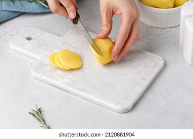 Step-by-step recipe of potato gratin. Hands cut potatoes on marble board. Potato casserole