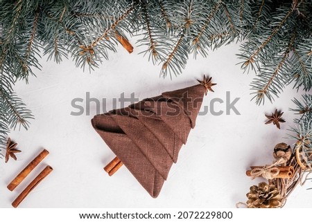 Step-by-step tutorial: Fold linen napkin in shape of Christmas tree. New Year table setting. Step 10: Add anise star and cinnamon stick for top and trunk. Top view