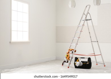 Stepladder And Different Tools Near Wall In Room. Interior Renovation