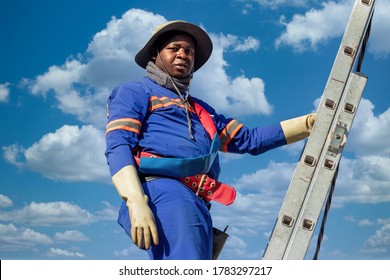 Stepladder Holding An African American Electrician On A Pole, Repairing A Transformer