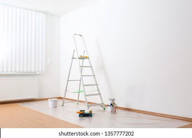 Stepladder And Painting Tools Near Wall In Empty Room