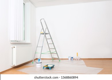 Stepladder And Painting Tools Near Wall In Empty Room