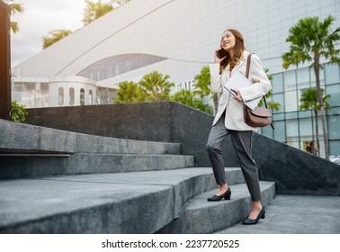 Stepping going up stairs in city, Business woman hold laptop computer talking mobile phone she hurry up walking on stairway, rush hour to work in office a hurry in morning, step up success, Full body - Powered by Shutterstock