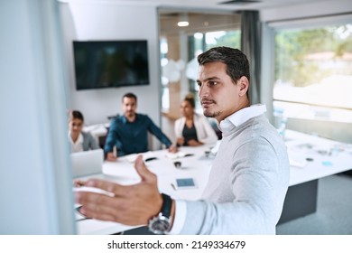 Stepping Up To Put Ambition Into Action. Shot Of A Young Businessman Giving A Presentation To His Colleagues In An Office.