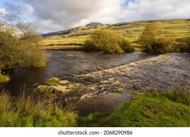 Stepping Stones Covered By Fast Flowing Water On The River Doe Above Inleton With Ingleborough In The Background With Blue Skies