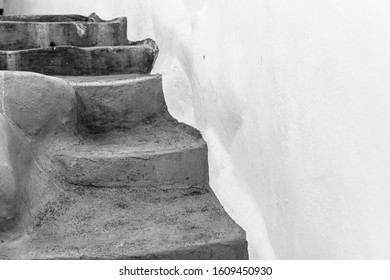 Steps against whitewashed wall where steps seem to randomly lead everywhere yet always end up at a door. - Shutterstock ID 1609450930