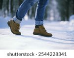 Steps along the snow-covered path. A man walks in the park in the winter.
