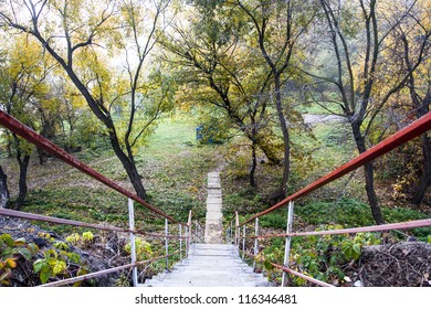 Steps for descent in autumn park in a fog