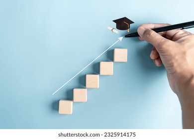Steps of education leading to success goal. Taking strategic steps towards graduation. Career path and first for business, Graduation achievement goals concept. Graduation cap on wooden block. - Shutterstock ID 2325914175