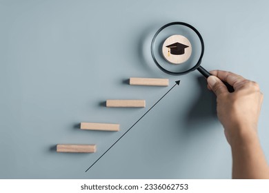 Steps of education leading to success goal. Taking strategic steps towards graduation. Career path and first for business, Graduation achievement goals concept. Graduation cap on wooden block.	