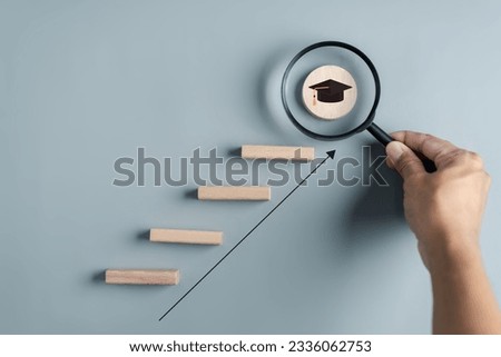 Steps of education leading to success goal. Taking strategic steps towards graduation. Career path and first for business, Graduation achievement goals concept. Graduation cap on wooden block.	