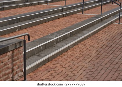 Steps of gray stone and bricks create a serene pathway. Brown leaves hint at autumn, while metal railings offer support. This quiet setting invites peaceful strolls.