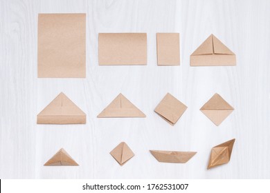 Steps Of Making Origami Paper Boat On White Wooden Background.