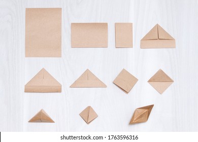 Steps Of Making Origami Paper Boat On White Wooden Background.