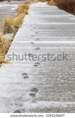 steps on fresh fallen snow on a pedestrian wooden path outdoor