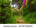 Steps on the pathway through the azaleas, leading towards the 15 meter tall bronze statue of the compassionate Kannon bodhisattva, also known as Kuan Yin, at Shiofune Kannon-Ji, Ome, Tokyo, Japan