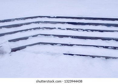 Steps in the snow at entrance to the building in winter, slippery stairs. - Shutterstock ID 1323944438