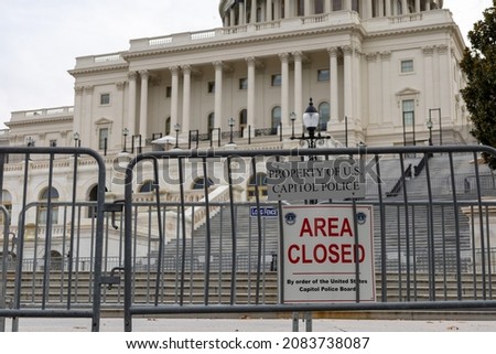 Steps to US capitol building closed off with riot fence and area closed sign.  No visible people