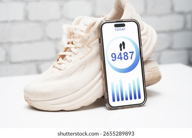 Step-tracking app displayed next to white athletic shoes. Fitness and health concept. Mobile pedometer, active lifestyle, and daily activity monitoring