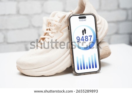 Step-tracking app displayed next to white athletic shoes. Fitness and health concept. Mobile pedometer, active lifestyle, and daily activity monitoring