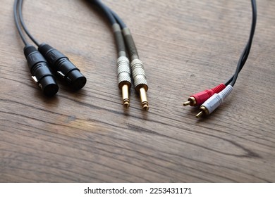 Stereo connections. XLR balanced, phone jack and Stereo phono plug connector on a rustic wooden table.  - Shutterstock ID 2253431171