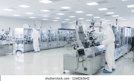 Sterile High Precision Manufacturing Laboratory where Scientists in Protective Coverall's Turn on Machninery, Use Computers and Microscopes, doing Pharmaceutics, Biotechnology Semiconductor Research.