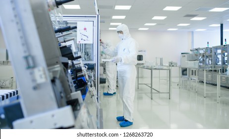 Sterile High Precision Manufacturing Laboratory where Scientists in Protective Coverall's Turn on Machninery, Use Computers and Microscopes, doing Pharmaceutics, Biotechnology and Semiconductor
