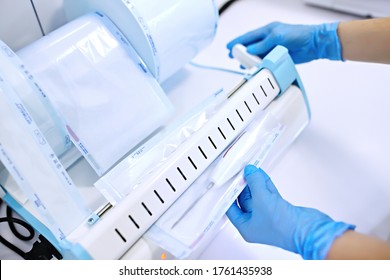 Sterilizing Box. Sterilization Of Instruments. Dentist Tools. Sterilization Procedure. Hands In Blue Gloves Holding Dentist Tools.