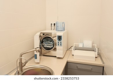 Sterilizing medical instruments in autoclave. Dental office. Selective focus. Sterile dental tools - Shutterstock ID 2338253753