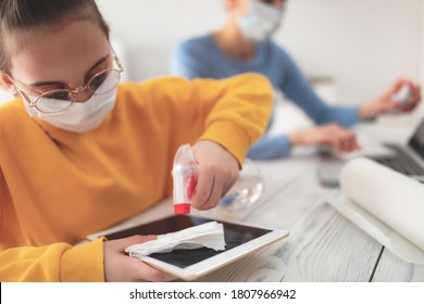 Sterilizing Tablet And Laptop. Child At Home Studying Education, Homeschooling, With Private Tutor / Mother With Protective Mask In The Time Of Viruses, Flu And Pandemic.