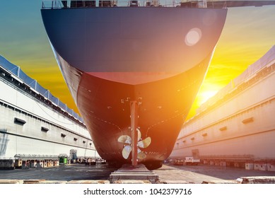Stern ship propeller big cargo ship under the Overhauled in floating dry dock in shipyard thailand on sunset background