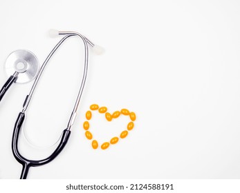 A Stethascope And A Heart Of Pills On A White Background.