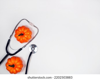 Stethascope And Pumpkins On A Light Background. Halloween Concept.