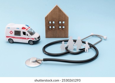 Stethoscope, ambulance toy, wooden house and family cutouts on blue background representing healthcare and emergency services - Powered by Shutterstock