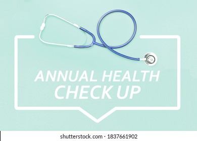 Stethoscope And Annual Health Check Up Text On Blue Background.