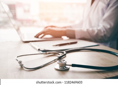 Stethoscope and background doctor using laptop at desk in clinic working on computer at room office. - Shutterstock ID 1182469603