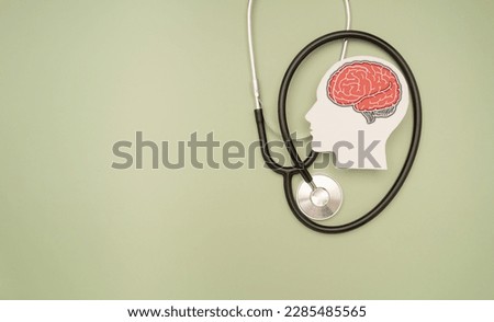 A stethoscope and a brain-shaped symbol on a green background. Awareness of mental health issues, dementia, Parkinson's disease, stroke, and seizures. psychological and neurological treatment Foto stock © 