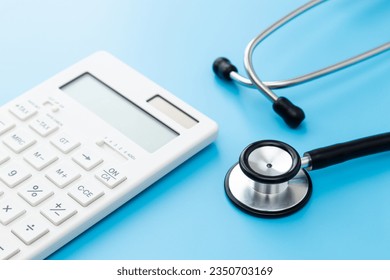 Stethoscope and calculator on blue background. - Powered by Shutterstock