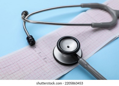 Stethoscope And Cardiogram Paper On Light Blue Background, Closeup