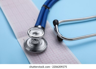 Stethoscope And Cardiogram Paper On Light Blue Background, Closeup