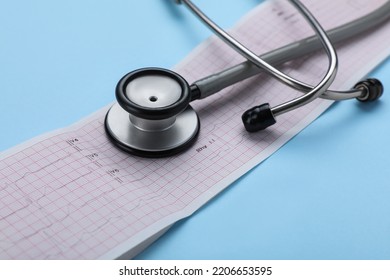 Stethoscope And Cardiogram Paper On Light Blue Background, Closeup