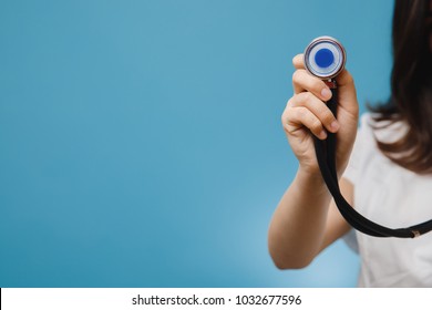 Stethoscope close-up. Nurse doctor girl in white dressing gown holds tool. Concept of medical care, insurance, store with medicine.