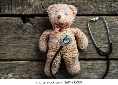 Stethoscope Disc On A Teddy Bear Toy Placed On Rustic Wooden Background. Pediatric Medicine Conceptual Image.