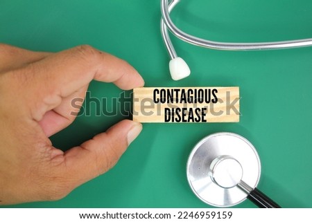 stethoscope and finger holding a stick with the word infectious disease. concept of infectious disease. dangerous disease