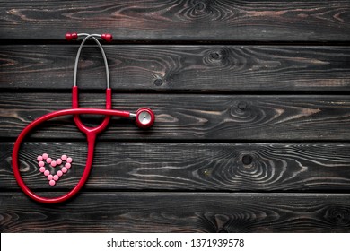 stethoscope and heart for diagnostic and cure of heart disease on wooden background top view mockup - Shutterstock ID 1371939578
