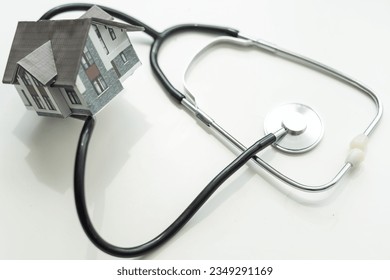 Stethoscope and house on wooden table. House inspection, repairing and diagnostic concept - Powered by Shutterstock